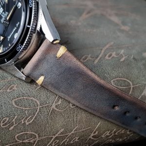 Gurney 1 vintage leather strap by gunny straps with mysterious grey brown color shown on omega seamaster speedmaster wristwatch