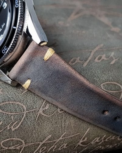 Gurney 1 vintage leather strap by gunny straps with mysterious grey brown color shown on omega seamaster speedmaster wristwatch