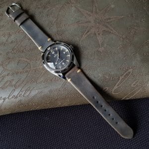 Gurney 1 vintage leather strap by gunny straps with mysterious grey brown color shown on omega seamaster speedmaster wristwatch