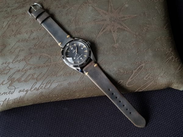 Gurney 1 vintage leather strap by gunny straps with mysterious grey brown color shown on omega seamaster speedmaster wristwatch