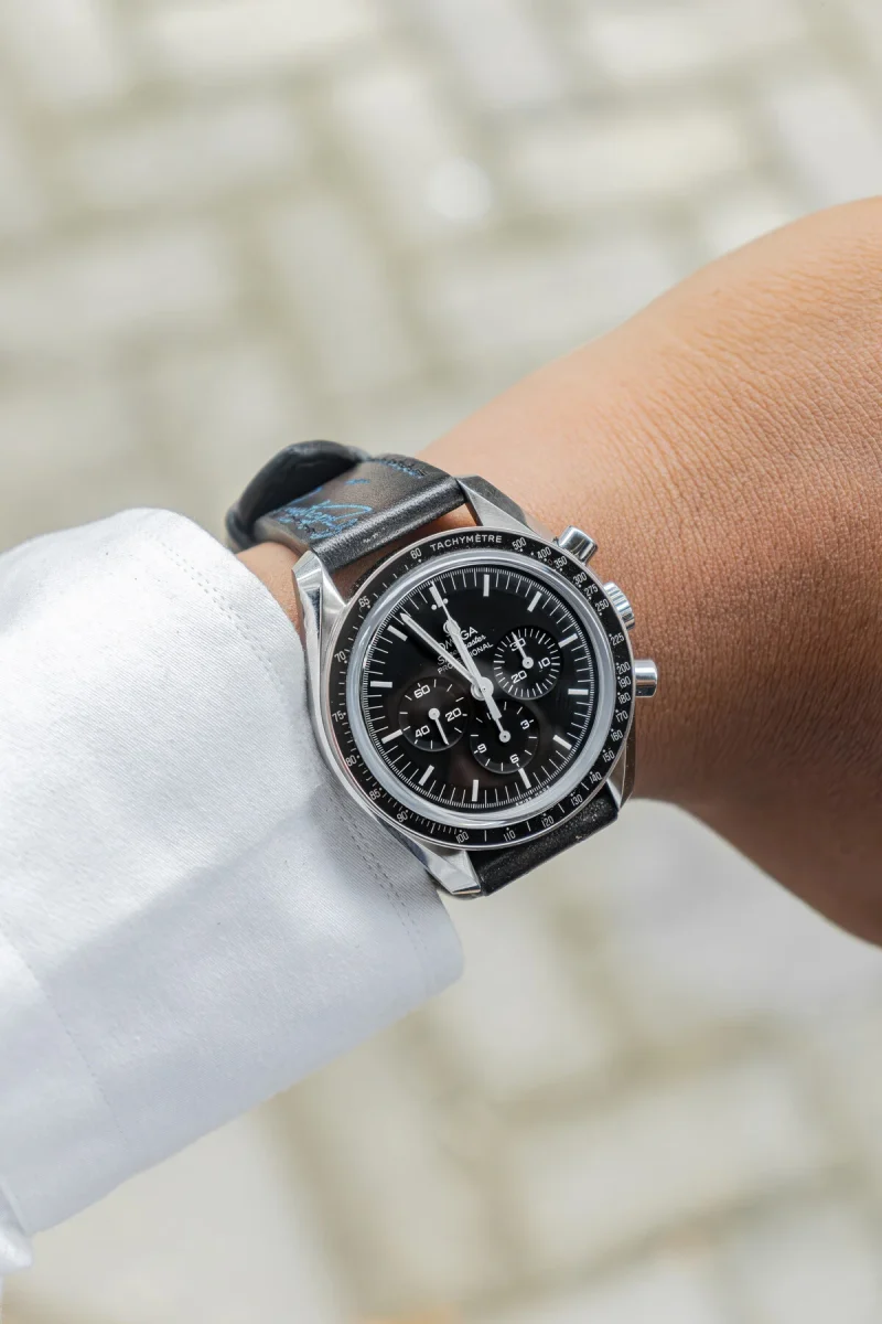 Black Patina with Blue Scritto Strap on Omega Speedmaster by Gunny Straps
